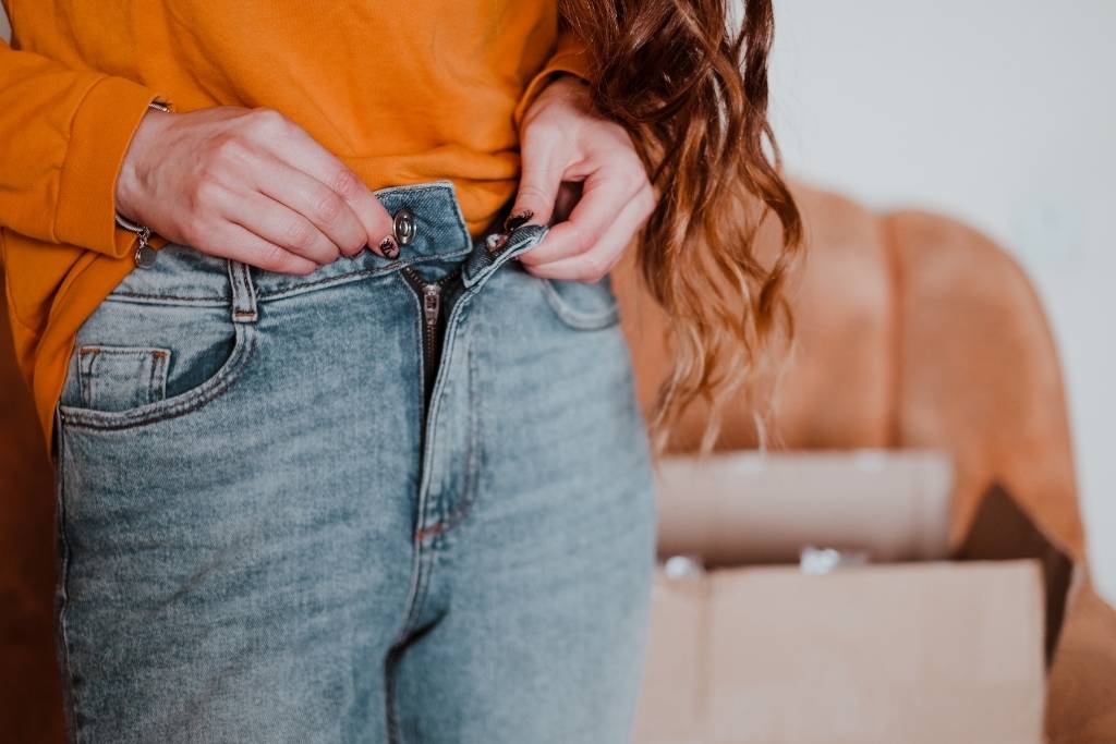 woman putting on jeans
