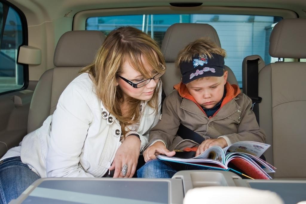 adult and child in backseat of car
