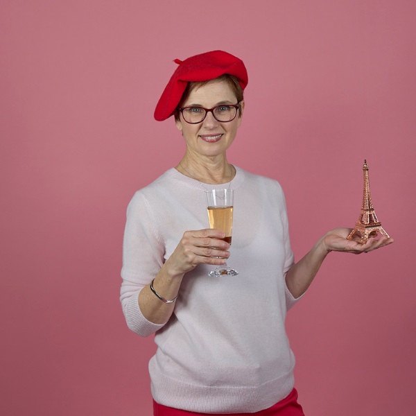 Andi in Quince sweater and beret with glass of champagne and eiffel tower hero
