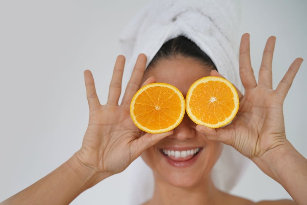 beauty in towel turban smiling with oranges