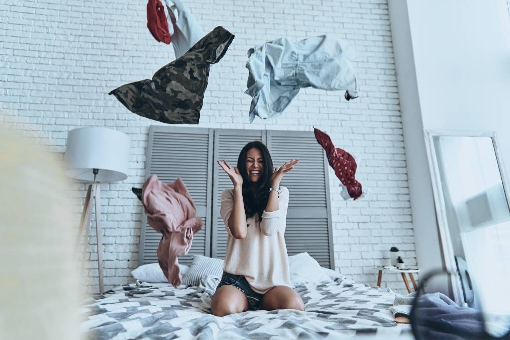 girl on bed with clothes everywhere