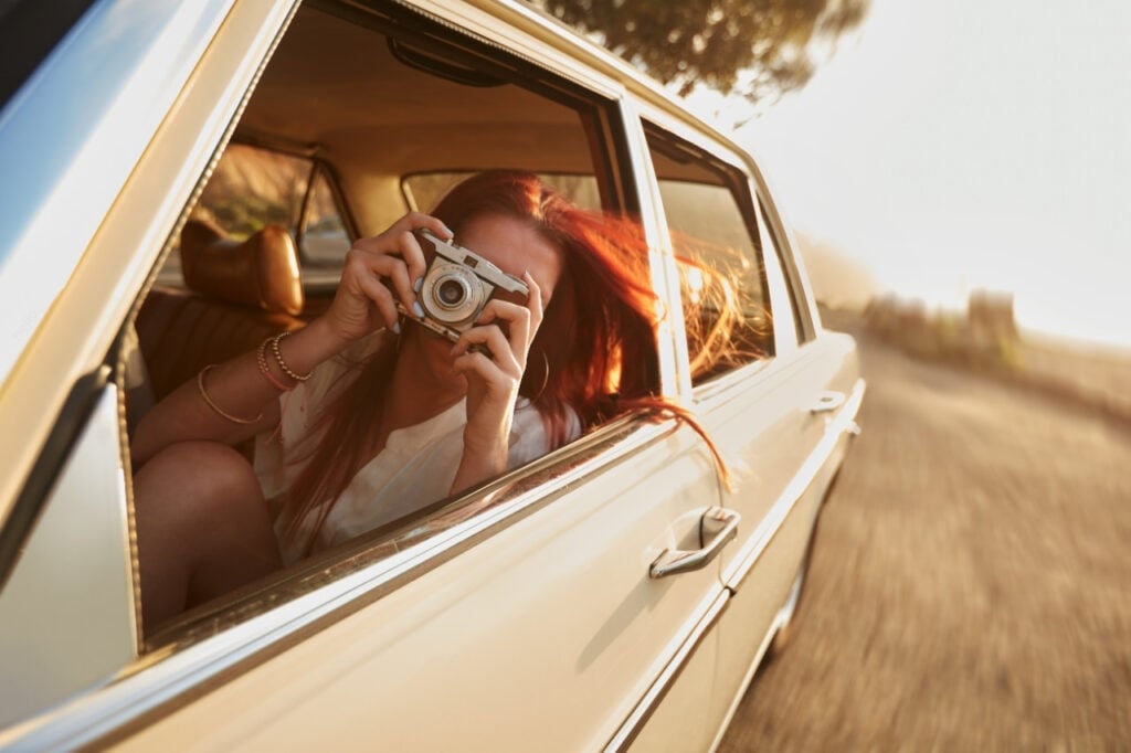 girl in car holding camera