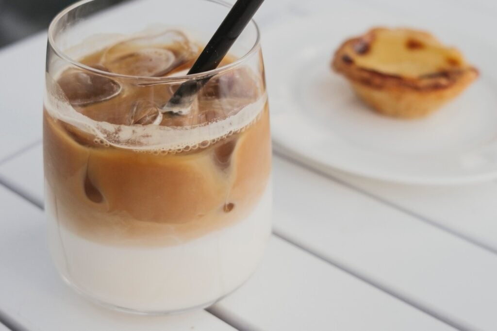 Glass with ice latte and black straw
