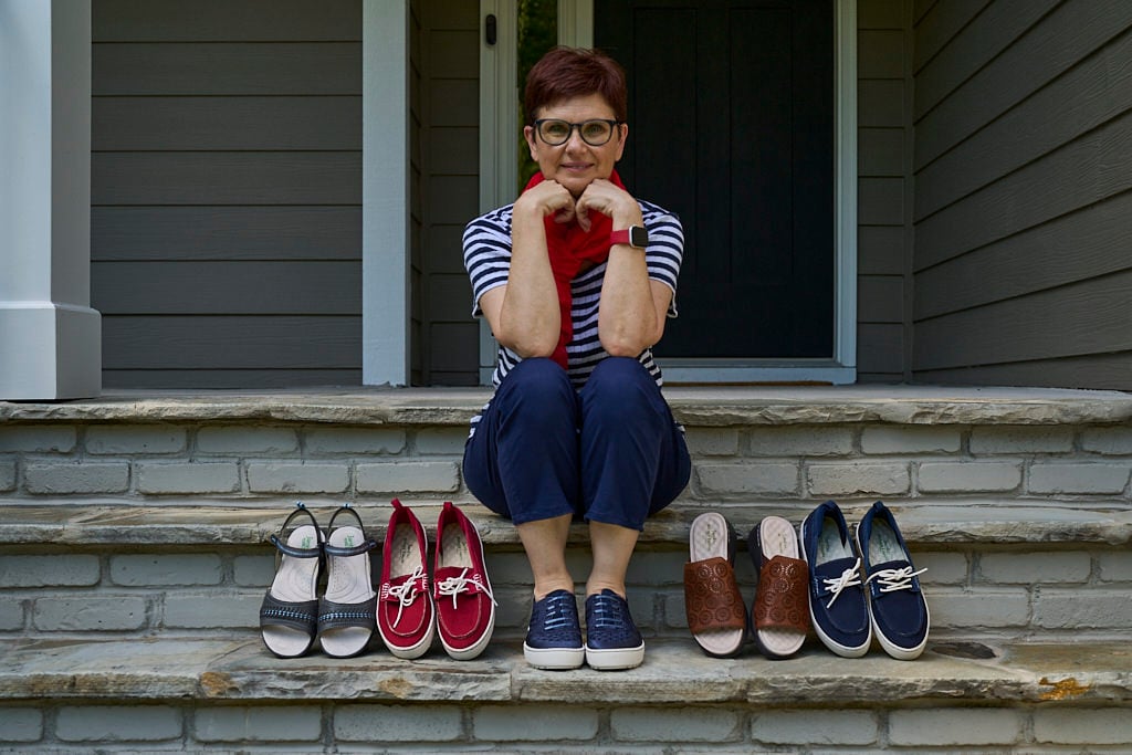 girl sitting with collection of shoes