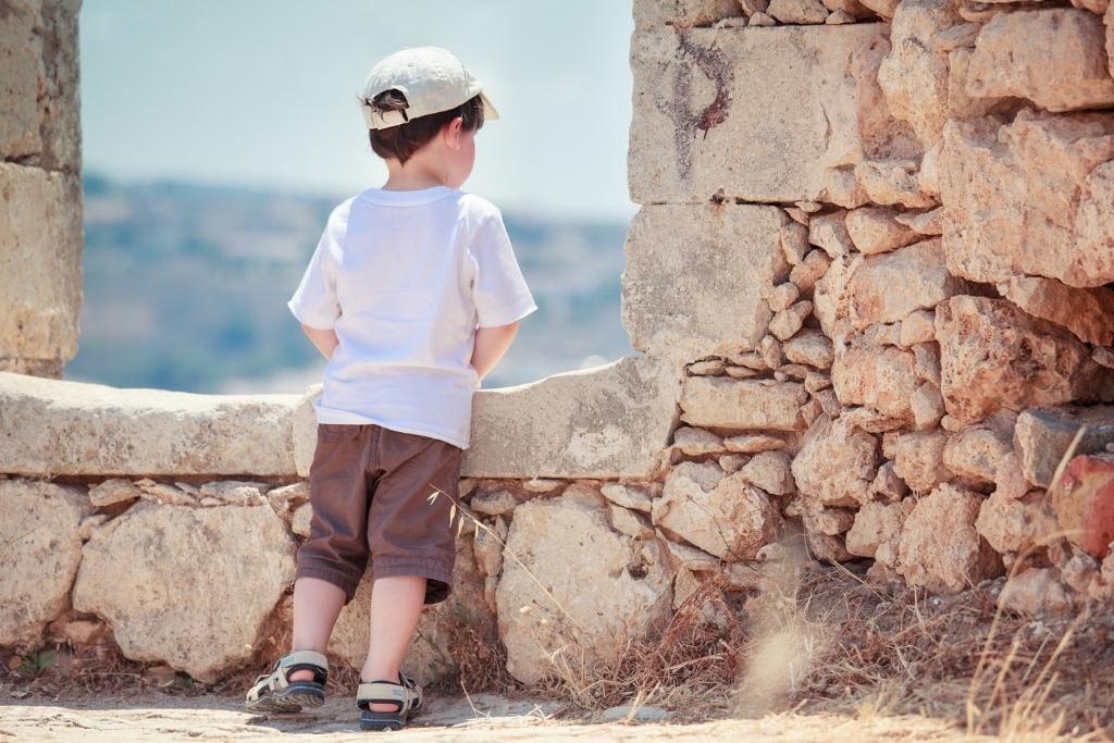 Little boy looking out a window