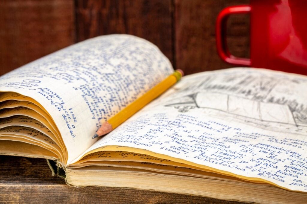 old journal with red coffee cup in background