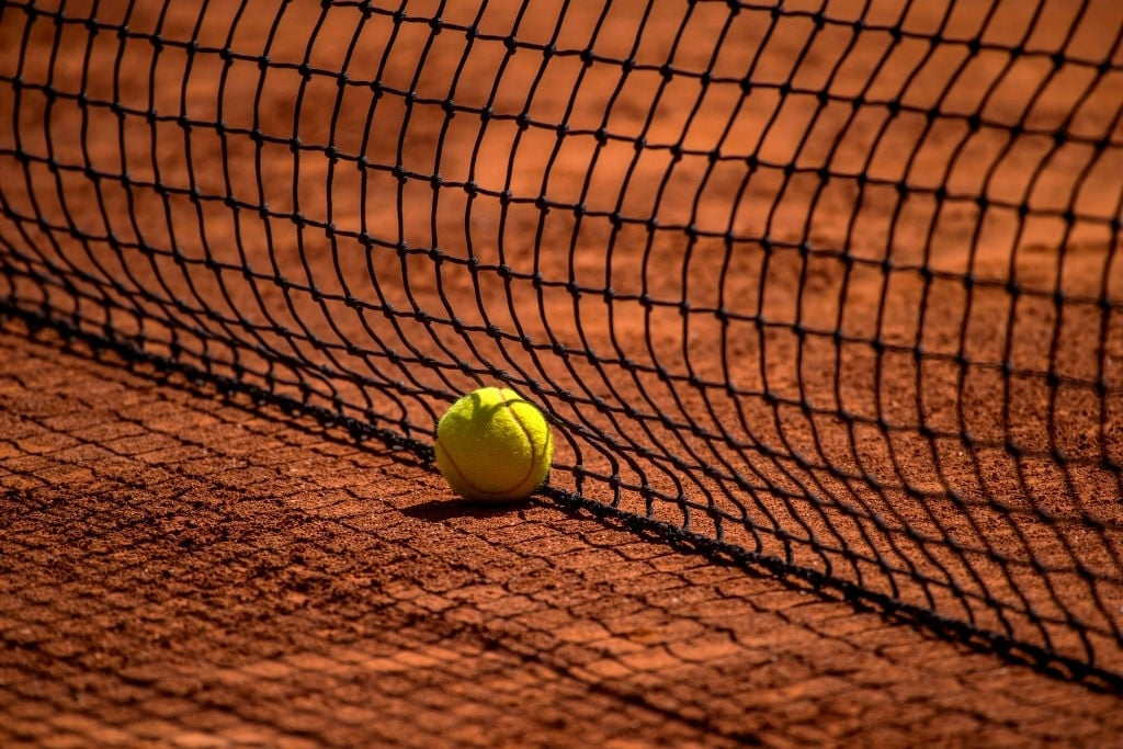 tennis ball on dirt court