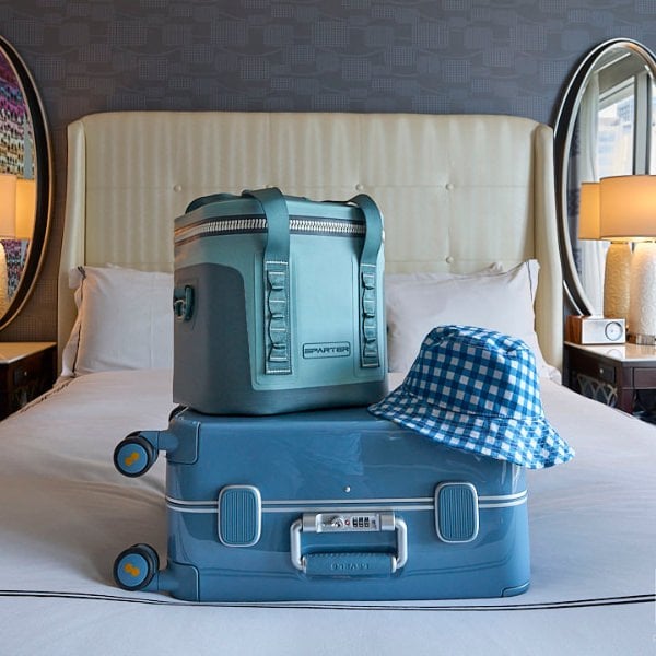 Sparter Cooler and luggage on a bed