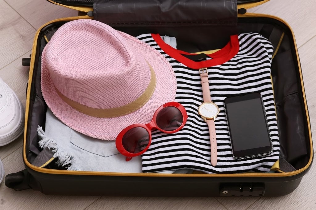 suitcase with pink hat and red sunglasses