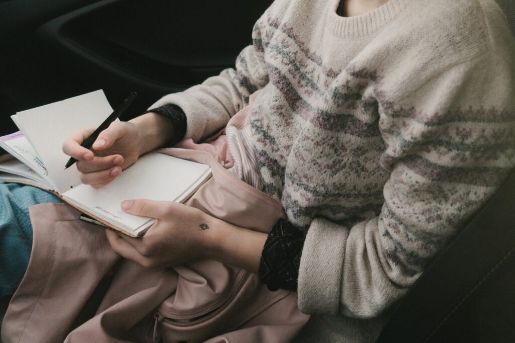 woman writing in notebook in cold weather