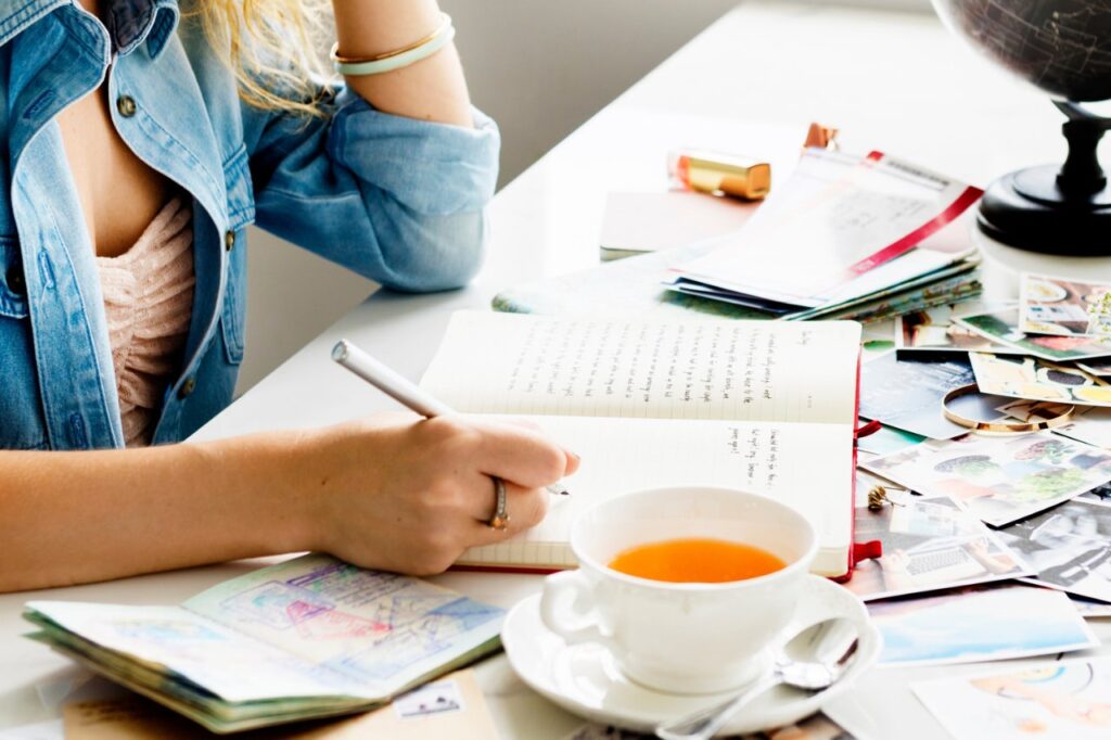 woman writing in notebook with souvenirs